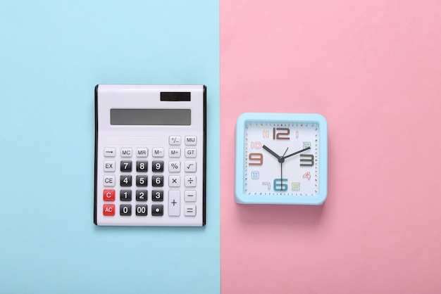 Calculator and clock on a pink blue background Top view