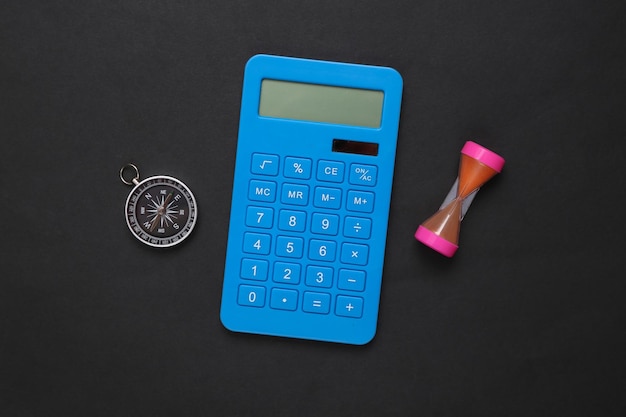 Calculator compass and hourglass on black background Business Income calculation investment deposit concept