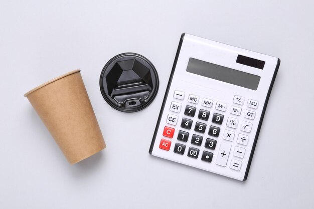 Calculator and craft coffee cup on gray background