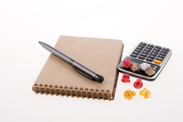 Calculator crumpled paper pollpoint pen and spiral notebook