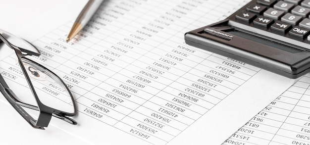 財務諸表の計算機と監査人の机の上のバランスシート会計と監査ビジネスの概念