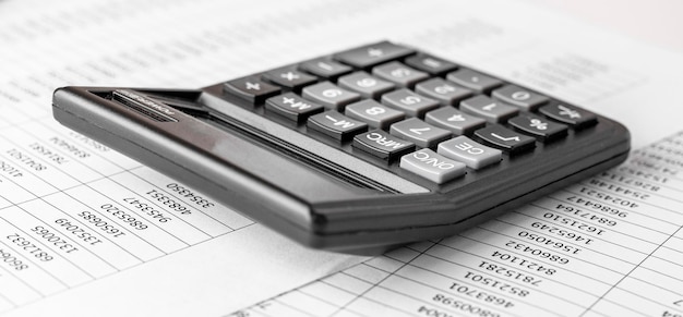 財務諸表の計算機と監査人の机の上のバランスシート会計と監査ビジネスの概念
