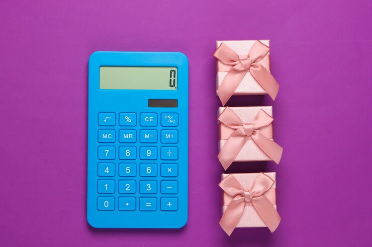 Photo calculator and gift boxes with a bow on purple. calculation of the value of the gift.