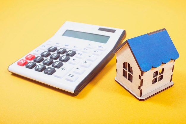 Calculator and house on orange background