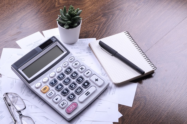 Calculator keypad with checks from the store from shopping on a wooden floor background