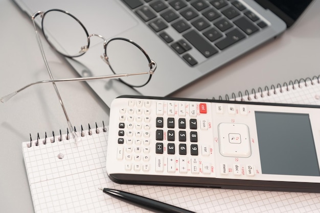 Photo calculator laptop and glasses on a gray background