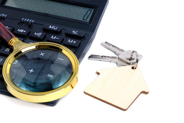 Calculator,magnifier and house keys.Concept of buying and selling housing, mortgages and renting a house or apartment.