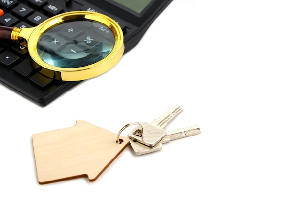 Calculator,magnifier and house keys.Concept of buying and selling housing, mortgages and renting a house or apartment.