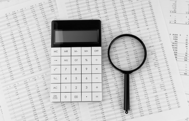 Calculator and magnifying glass on financial statement Financial accounting and business concept