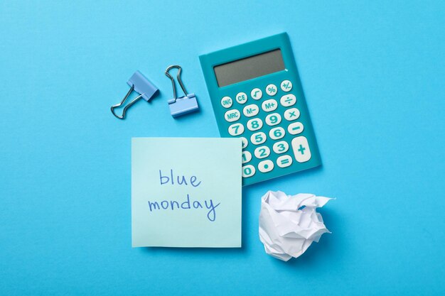 Calculator note paper and binders on blue background top view