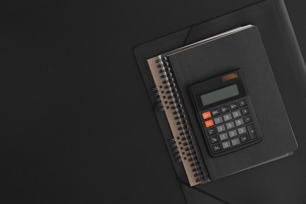 Блокнот калькулятора на черном кожаном фоне