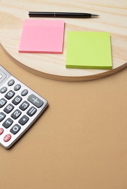 Calculator and pen near notepad on desk office