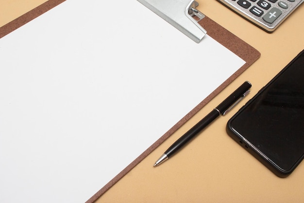 Calculator smartphone and clipboard on office table