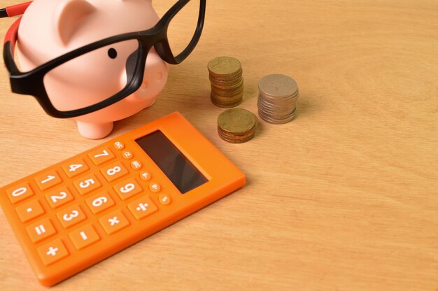 Calculator stack of coins and piggy bank Copy space