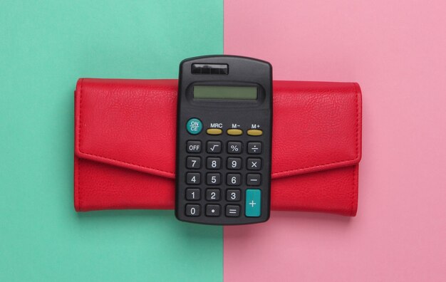 Calculator with a leather wallet on a blue-pink pastel.