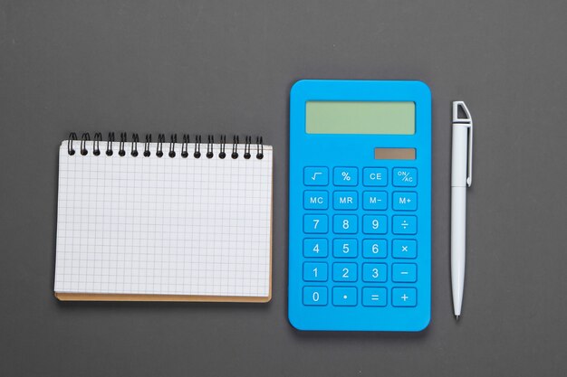 Calculator with a notebook on a gray. family budget management.