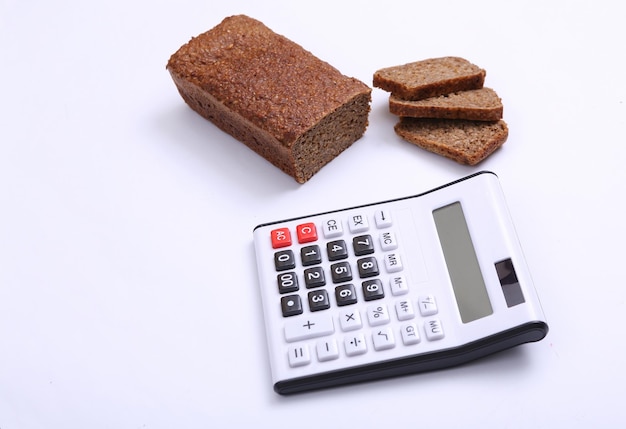 Calculator with Sliced whole grain rye bread on white background Diet calorie counting concept
