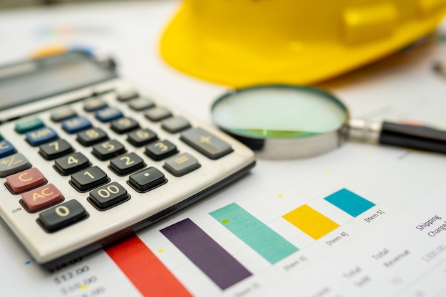 Calculator with yellow construction helmet on chart paper.