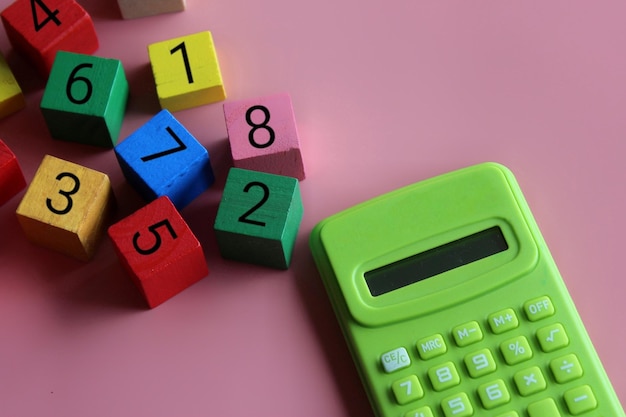 電卓と数学記号付きの木製立方体教育と数学の概念