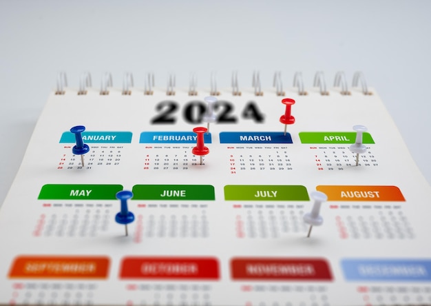 Foto calendario 2024 pianificazione pin colorato segna date importanti 2024 planner orologio calendario per impostare l'orario organizzare la pianificazione del programma per il concetto di pianificazione delle riunioni di lavoro