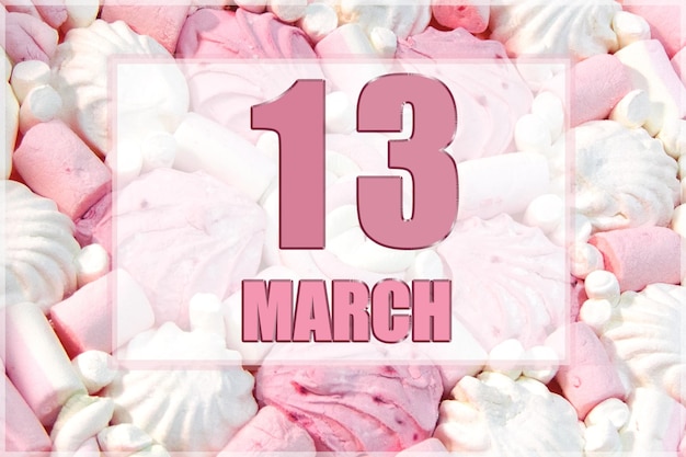 흰색과 분홍색 마시멜로를 배경으로 달력 날짜 3월 13일은 그 달의 13일입니다.