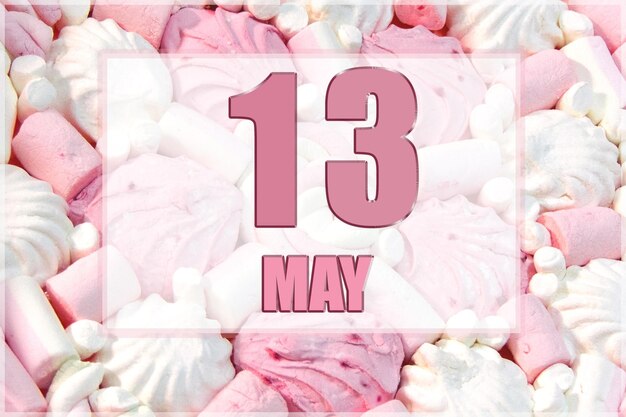 Calendar date on the background of white and pink marshmallows May 13 is the thirteenth day of the month