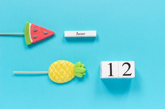 Data del calendario 12 giugno e frutta estiva caramelle ananas, lecca lecca cocomero.