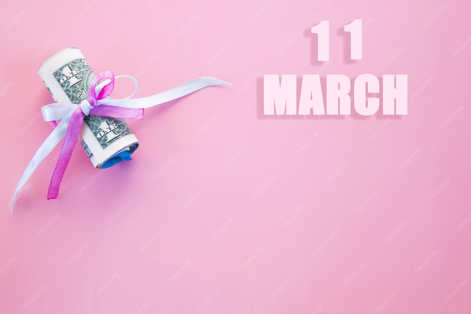 Premium Photo Calendar date on pink background with rolled up dollar