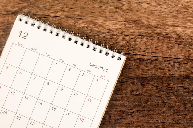 Scrivania del calendario 2021 nel mese di dicembre, calendario con vista dall'alto per l'organizzatore per la pianificazione sullo sfondo del tavolo in legno. concetto di riunione di appuntamento di pianificazione aziendale