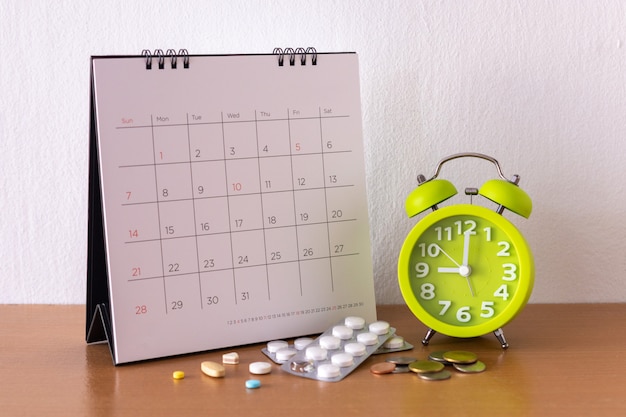 Calendar and drugs on table.