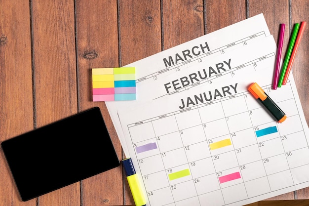 Календарь на первые месяцы года вместе с цифровым планшетом и красочной клейкой запиской