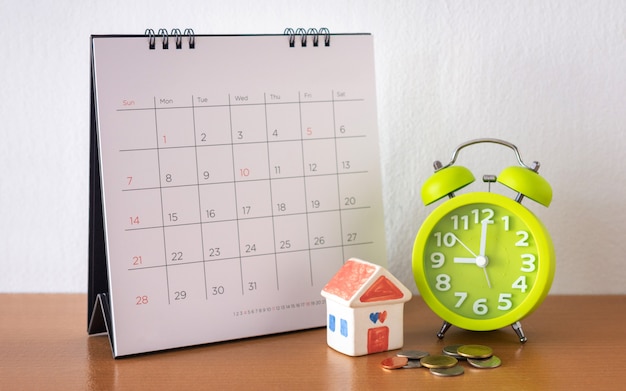 Calendario e casa sul tavolo. giorno di acquisto o vendita di una casa o pagamento per affitto o prestito.