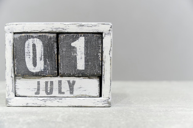 Calendar for July 01 made of wooden cubes on gray backgroundWith an empty space for your text