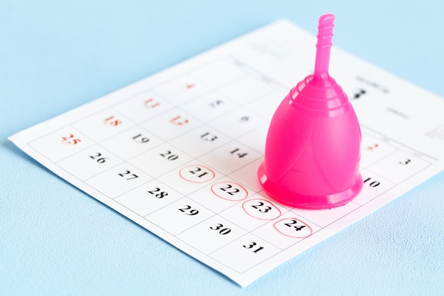 Calendar page and menstrual cup close up