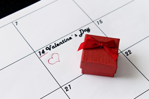 Calendar page with red hearts and a gift on February 14