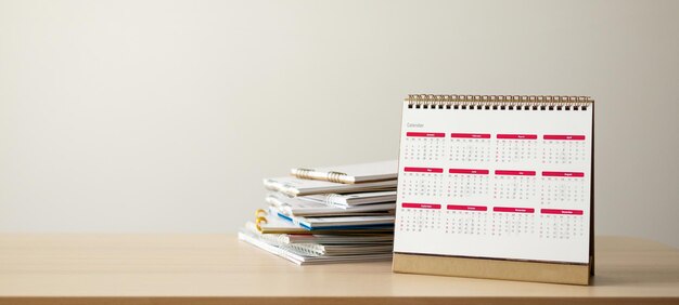 Photo calendar page on wood table with white wall background business planning appointment meeting concept