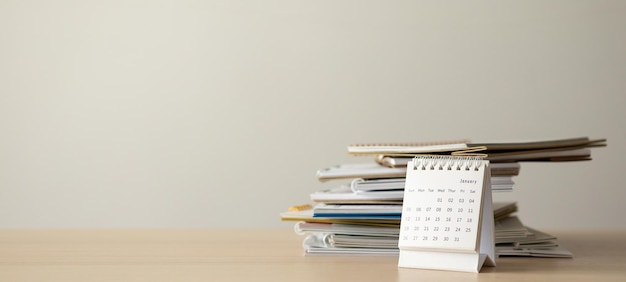 Calendar page on wood table with white wall background business planning appointment meeting concept