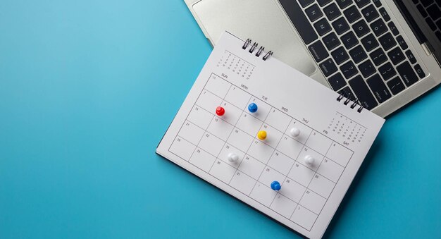 Calendar on solid blue background with copy space pinned in a
calender on datebusiness meeting schedule travel planning or
project milestone and reminder concept