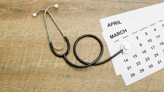 Calendario, stetoscopio, su sfondo blu, concetto di assistenza sanitaria.
