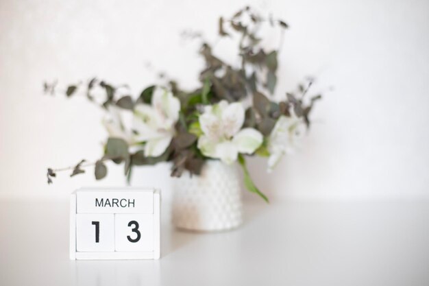 白いテーブルの上に花瓶と花瓶が置かれたカレンダー。