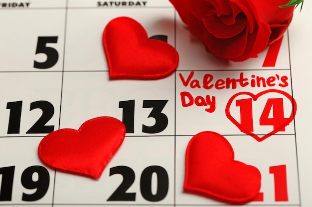 Calendar with date of February 14 and rose flower petals Valentines day concept