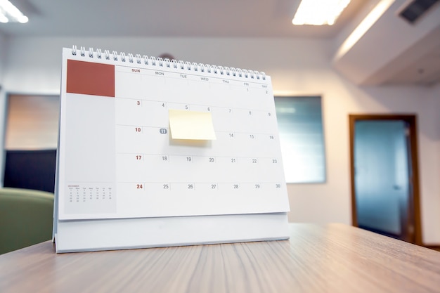 Calendar with paper note on office desk for events planner.