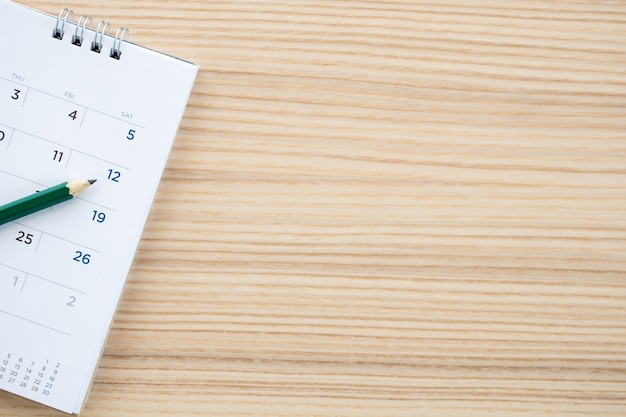 Calendar with pencil on wood table