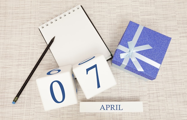 사진 트렌디 한 파란색 텍스트와 4 월 7 일 숫자 및 상자에 선물이있는 달력.