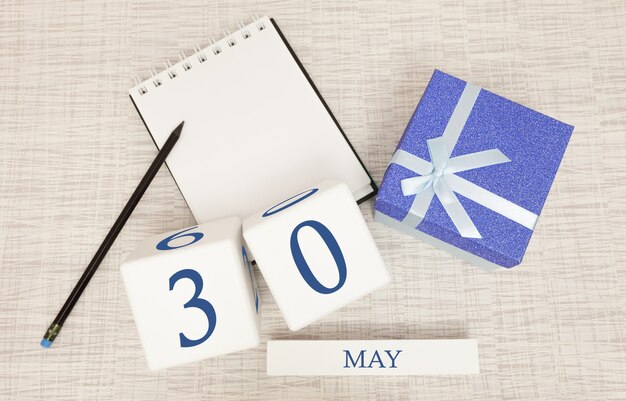 Фото Календарь с модным синим текстом и цифрами на 30 мая и подарком в коробке.
