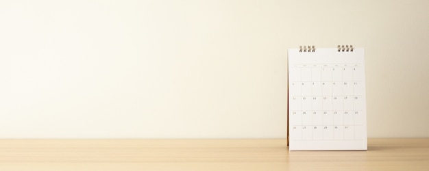 Calendar on wood table with white wall