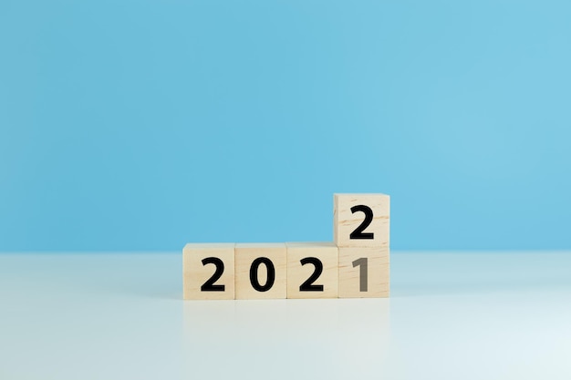 2021년부터 2022년까지 달력 나무 큐브 블록 변경 연도는 파란색 배경 앞으로 시작 새해 목표 12월부터 1월까지입니다.