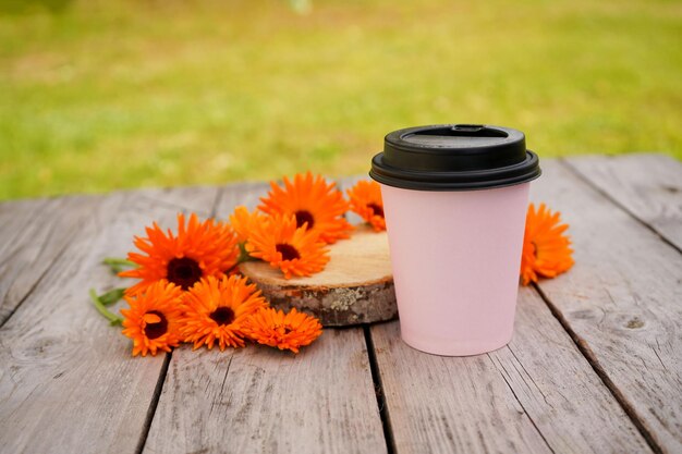 Calendula bloemen liggen op een oude houten tafel bij een glas koffie of thee Fytotherapie