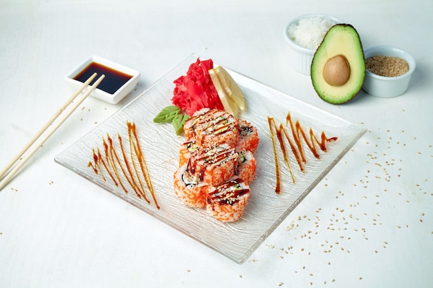 California sushi roll with eel, cucumber and tobiko caviar on a white plate