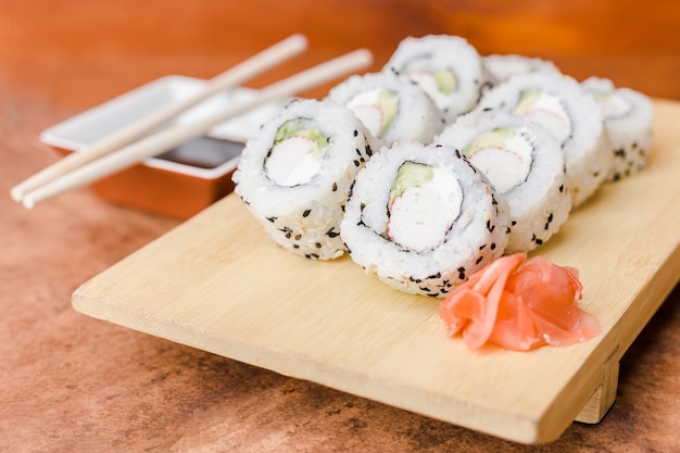 California sushi roll with soy sauce on a wooden table